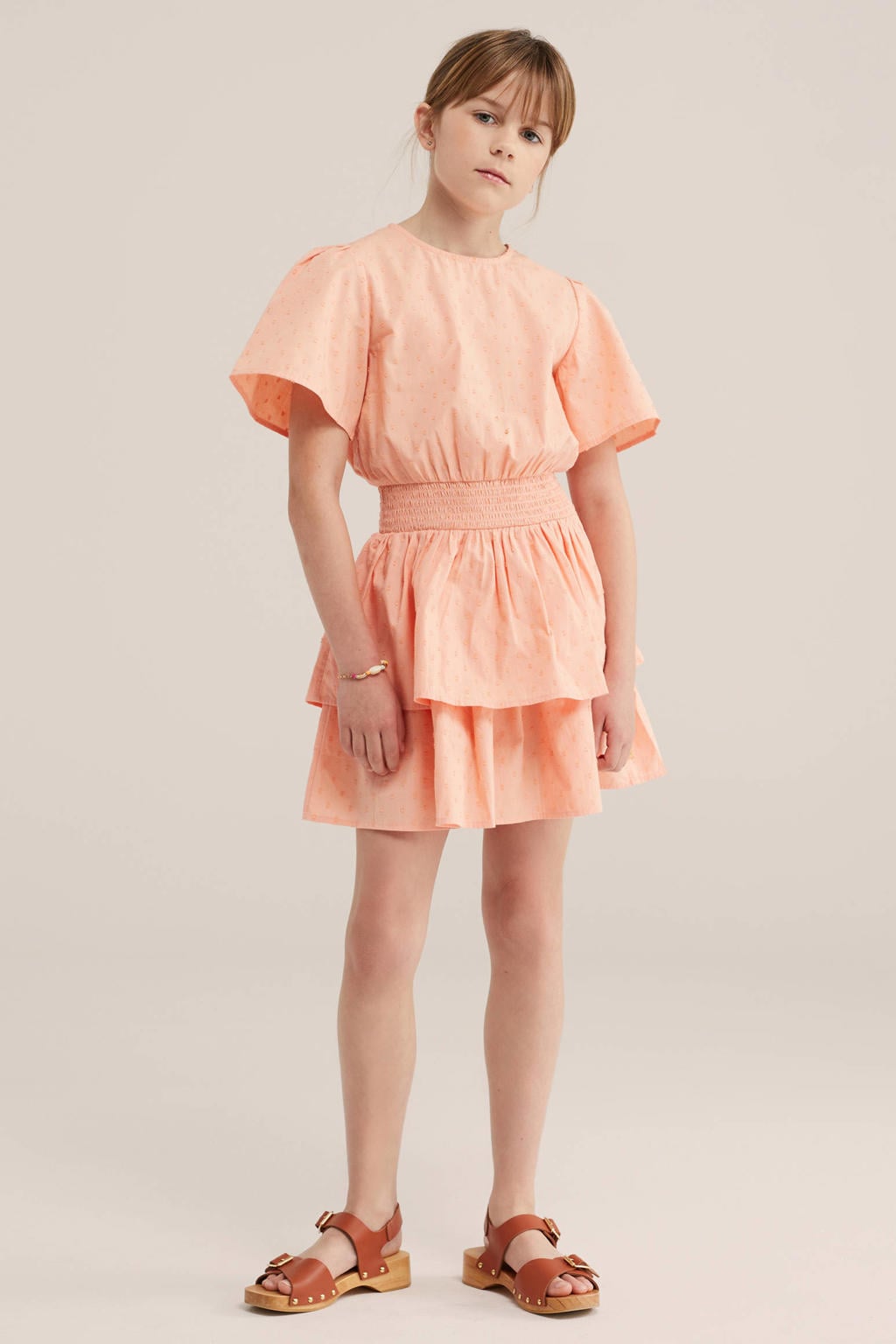 Zalmkleurige meisjes WE Fashion blousejurk van katoen met stippenprint, korte mouwen, ronde hals, knoopsluiting en smockwerk
