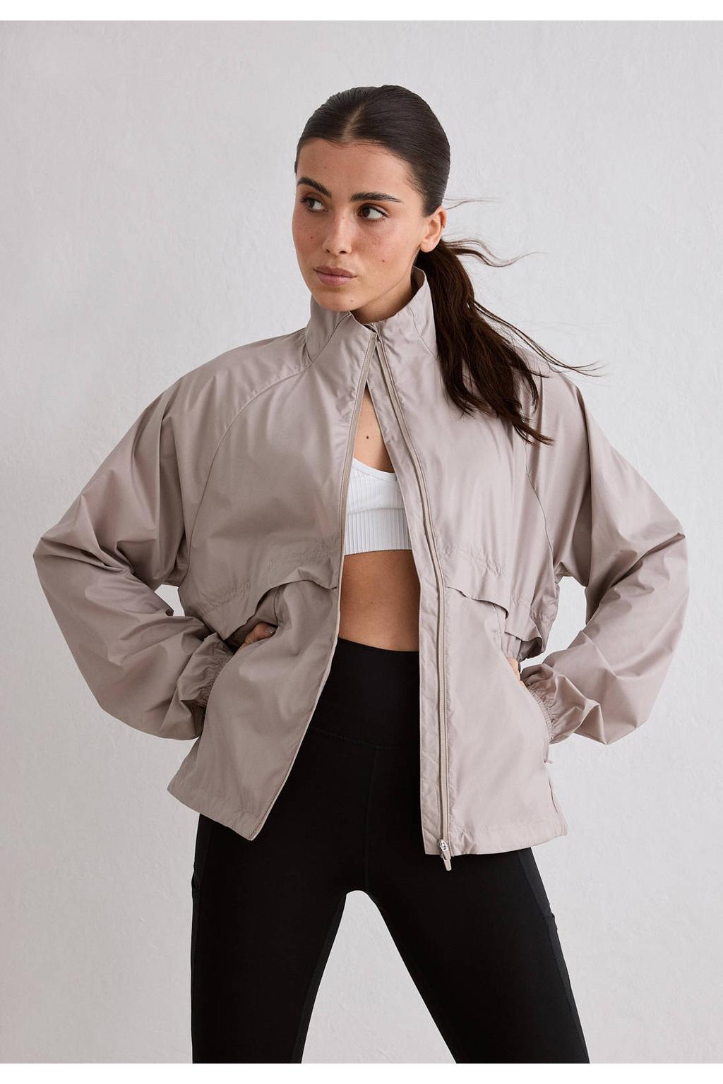Zandkleurige dames Aim'n Le Run hardloopjack van polyester met lange mouwen en opstaande kraag