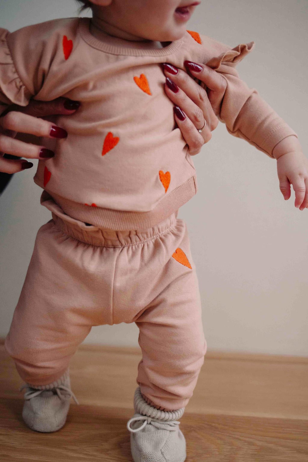 Lichtbruin en oranje meisjes Riffle Amsterdam sweater en hartjes met lange mouwen, ronde hals, knoopsluiting en ruches